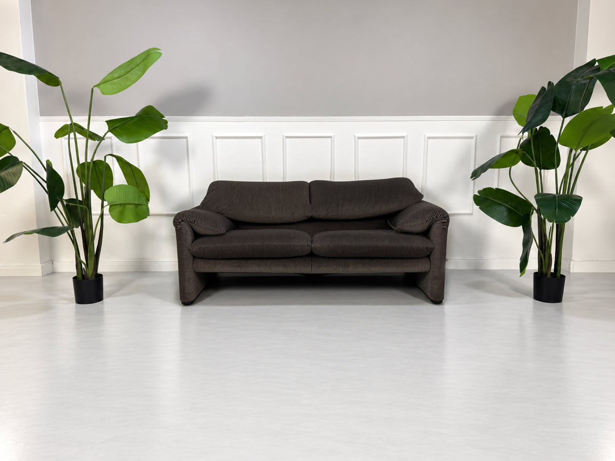 Gebrauchtes braun-schwarzes Cassina Maralunga Designer Stoff Sofa vor einer Wand, stilvoll und modern eingerichtet.