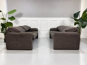 Gebrauchtes braun-schwarzes Cassina Maralunga Designer Stoff Sofa vor einer Wand, stilvoll und modern eingerichtet.