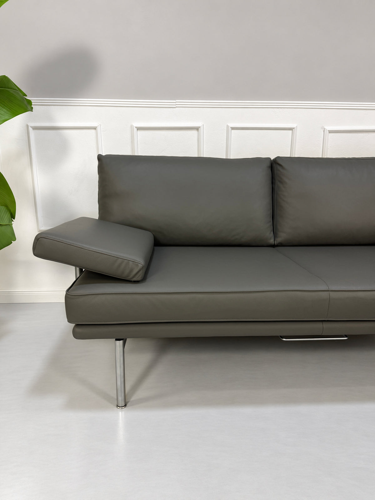 Gebrauchtes graues Walter Knoll Living Platform Designer Leder Sofa vor einer Wand, stilvoll und modern eingerichtet.
