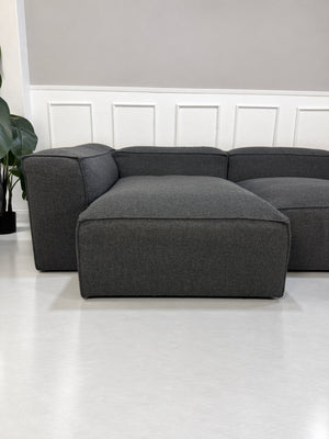 Gebrauchtes graues Bolia Cosima Designer Stoff Sofa vor einer Wand, stilvoll und modern eingerichtet.