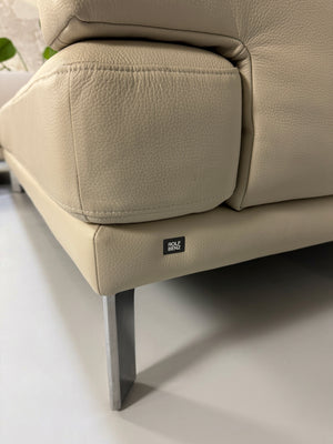 Gebrauchtes beiges Rolf Benz Sento 344 Designer Leder Ecksofa mit Hockerbank vor einer Wand, stilvoll und modern eingerichtet.