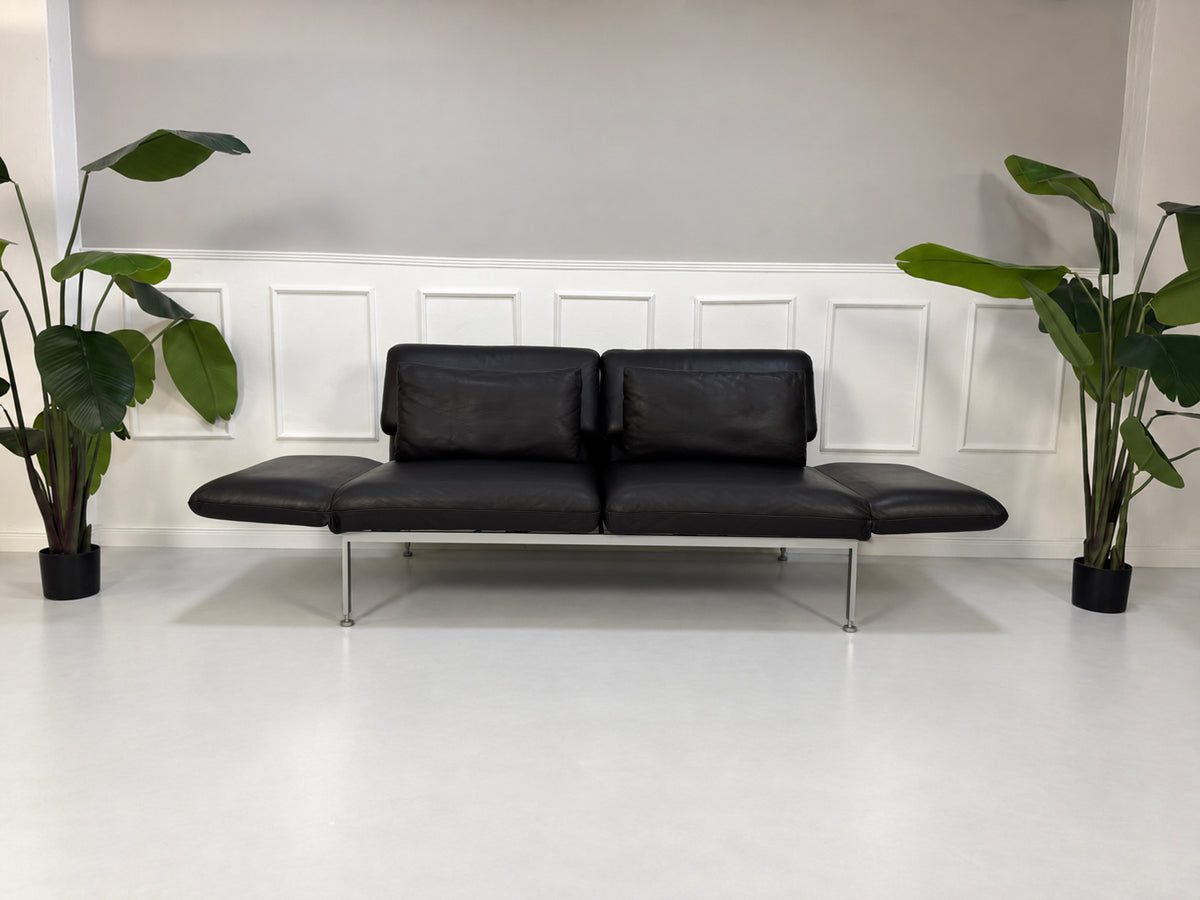 Gebrauchtes schwarzes Brühl Roro Medium Designer Leder Sofa vor einer Wand, stilvoll und modern eingerichtet.