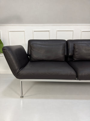 Gebrauchtes schwarzes Brühl Roro Medium Designer Leder Sofa vor einer Wand, stilvoll und modern eingerichtet.