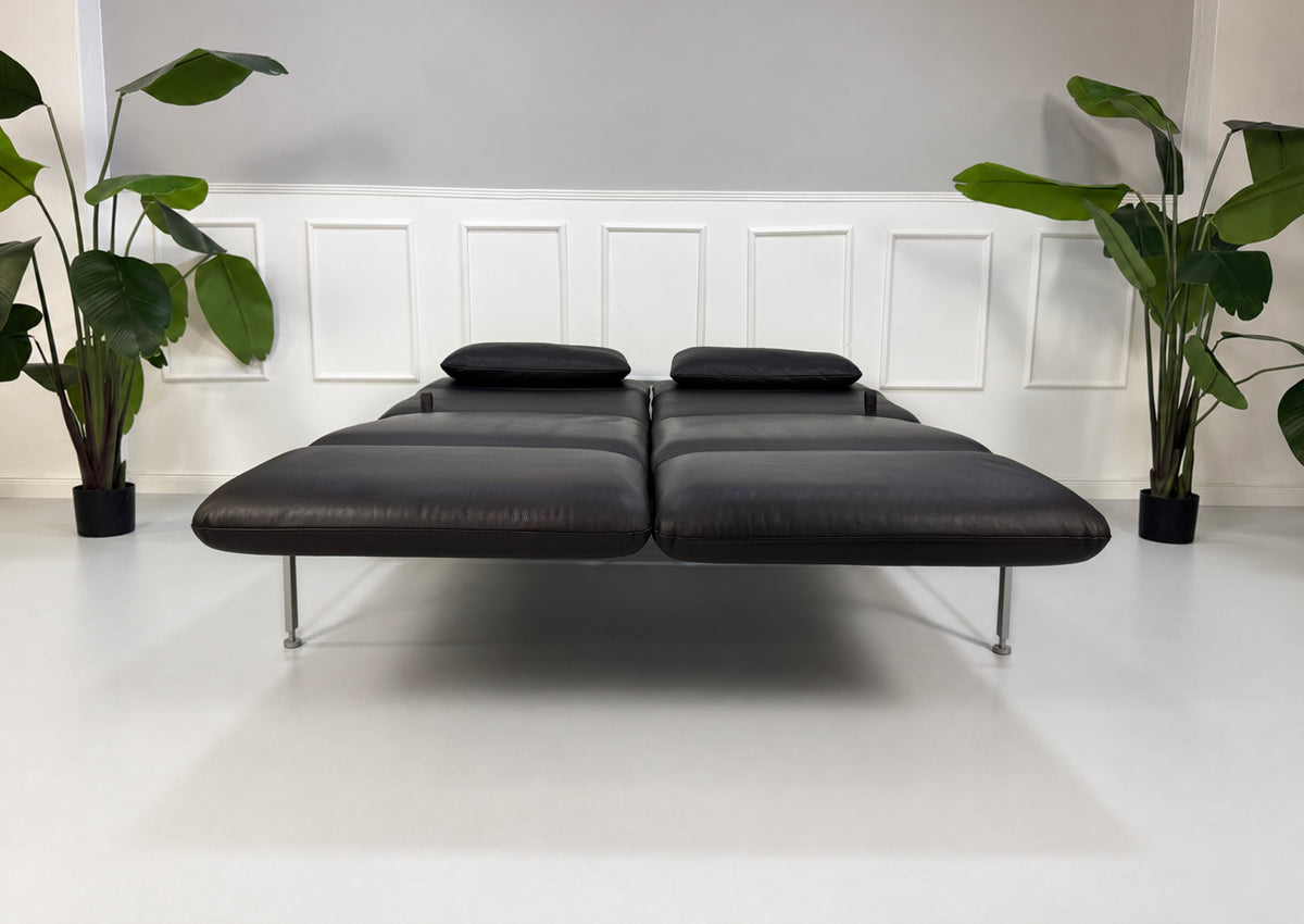 Gebrauchtes schwarzes Brühl Roro Medium Designer Leder Sofa vor einer Wand, stilvoll und modern eingerichtet.