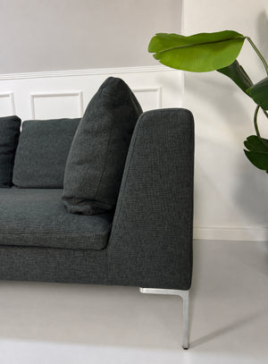 Gebrauchtes graues B&B Italia Charles Designer Stoff Ecksofa vor einer Wand, stilvoll und modern eingerichtet.