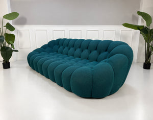 Gebrauchtes blaues Roche Bobois Bubble Designer Stoff Sofa vor einer Wand, stilvoll und modern eingerichtet.