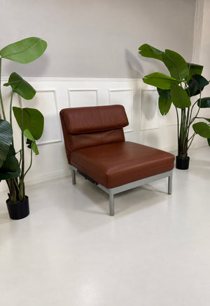 Gebrauchter brauner Rolf Benz Plura 380 Designer Leder Sessel vor einer Wand, stilvoll und modern eingerichtet.