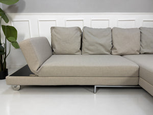 Gebrauchtes beiges Brühl Fourtwo Designer Stoff Ecksofa vor einer Wand, stilvoll und modern eingerichtet.