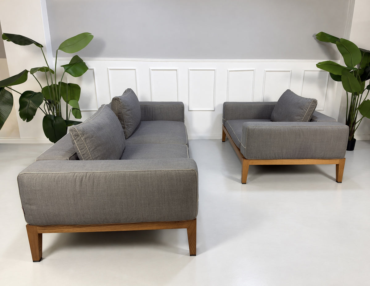 Gebrauchtes graues Flexform Lifewood Designer Stoff Sofa mit Love Chair vor einer Wand, stilvoll und modern eingerichtet.