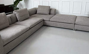 Gebrauchtes graues B&B Italia Michel Designer Stoff Sofa vor einer Wand, stilvoll und modern eingerichtet.