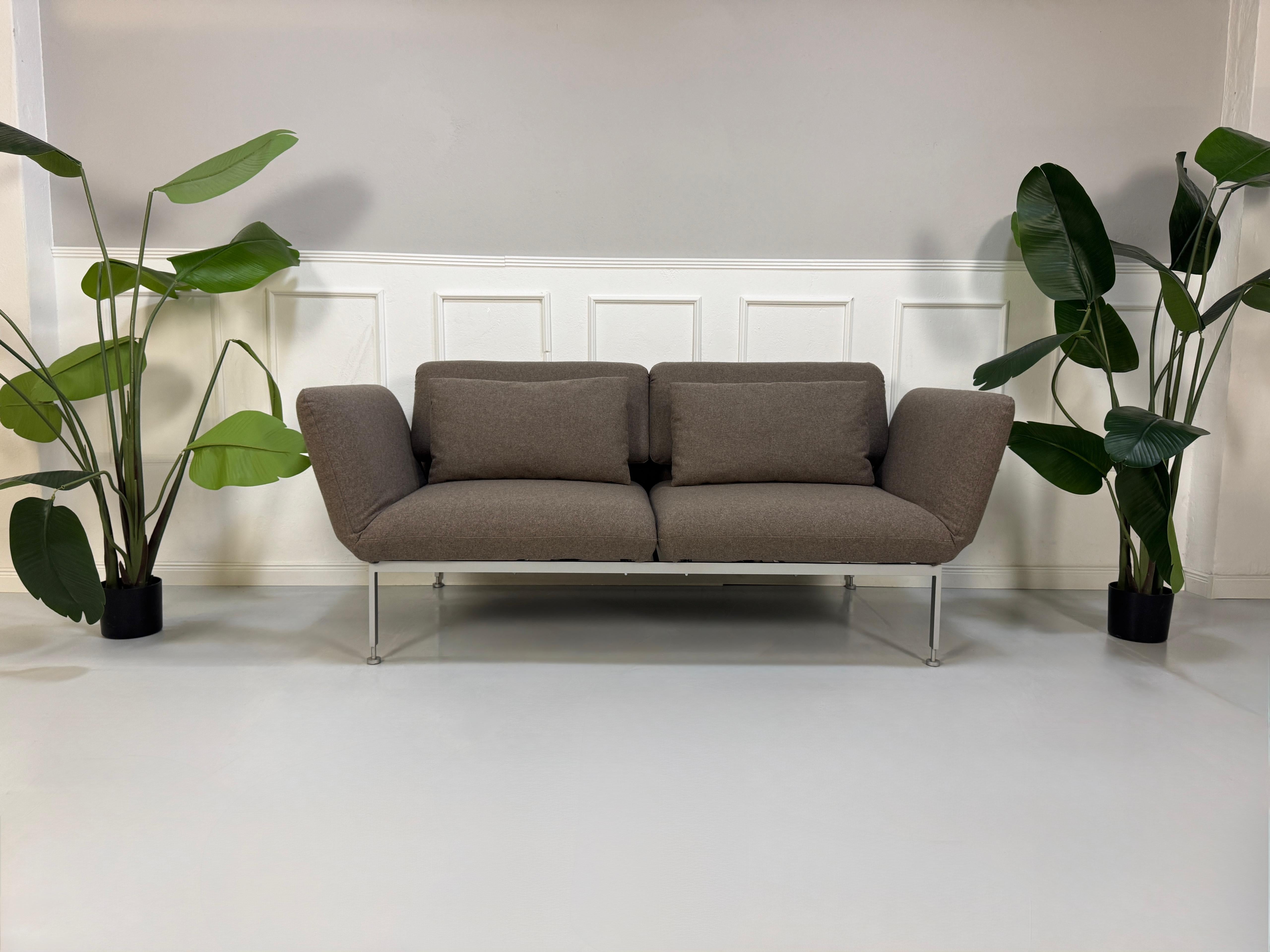 Gebrauchtes braunes Brühl Roro Designer Stoff Sofa vor einer Wand, stilvoll und modern eingerichtet.
