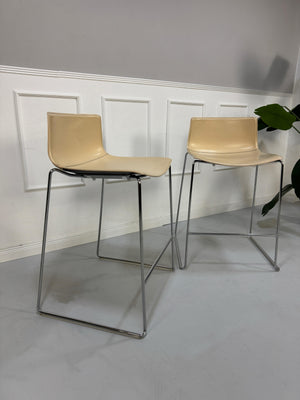 Gebrauchte beige Arper Catifa Designer Leder Stühle Barhocker vor einer Wand, stilvoll und modern eingerichtet.