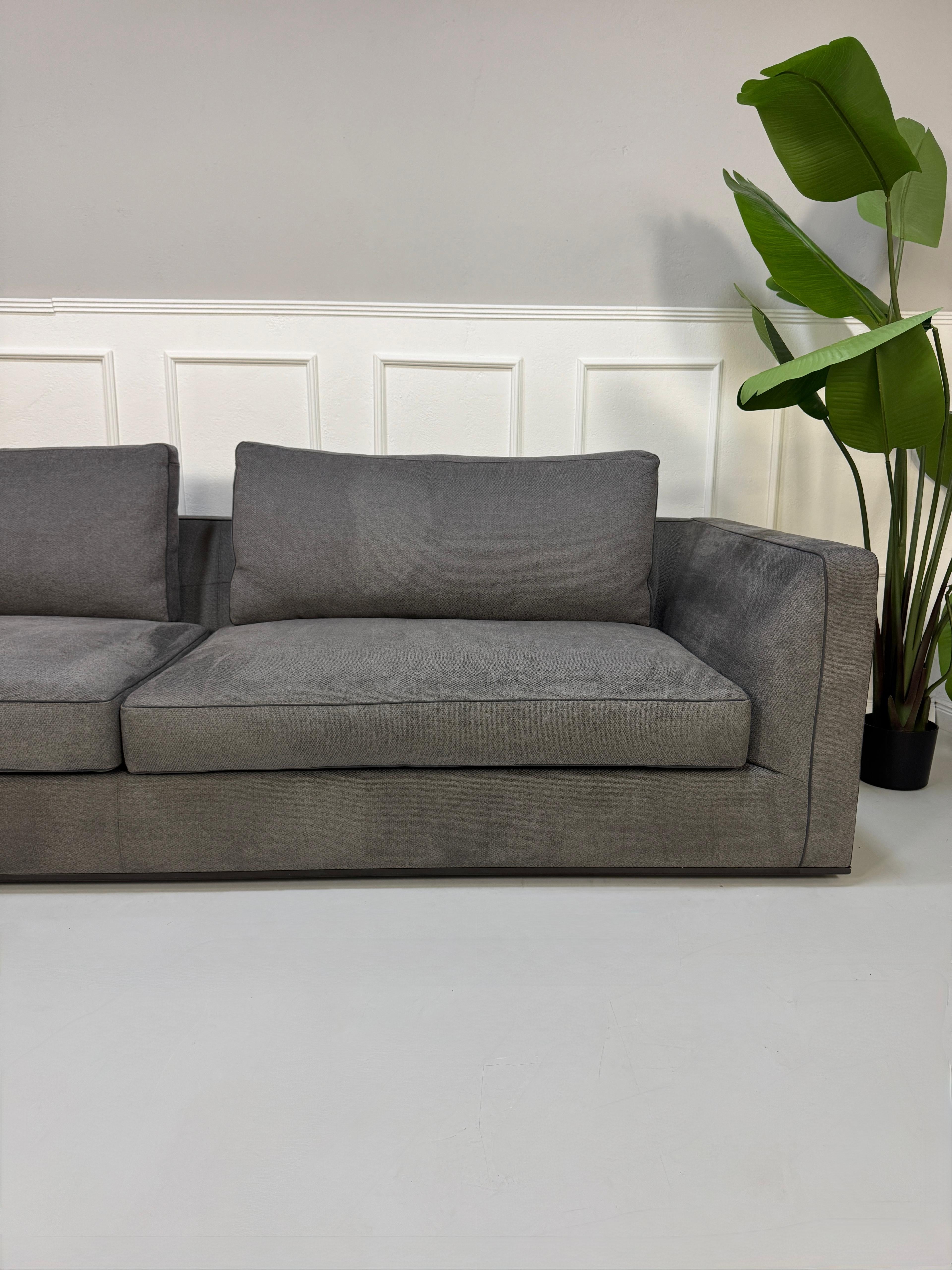 Gebrauchtes graues B&B Italia Richard Designer Stoff Sofa vor einer Wand, stilvoll und modern eingerichtet.