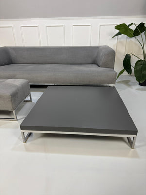 Gebrauchtes graues BB Italia Solo Designer Stoff Sofa mit Tavalo Tisch und Hocker vor einer Wand, stilvoll und modern eingerichtet.