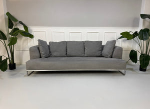 Gebrauchtes graues BB Italia Solo Designer Stoff Sofa mit Tavalo Tisch und Hocker vor einer Wand, stilvoll und modern eingerichtet.