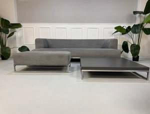 Gebrauchtes graues BB Italia Solo Designer Stoff Sofa mit Tavalo Tisch und Hocker vor einer Wand, stilvoll und modern eingerichtet.