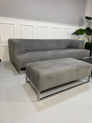 Gebrauchtes graues BB Italia Solo Designer Stoff Sofa mit Tavalo Tisch und Hocker vor einer Wand, stilvoll und modern eingerichtet.