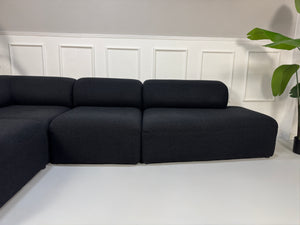 Gebrauchtes Bolia Angle Designer Stoff Sofa in der Farbe Schwarz vor einer Wand, stilvoll und modern eingerichtet.