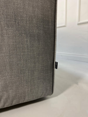 Gebrauchtes graues Bolia Cosima Designer Stoff Sofa vor einer Wand, stilvoll und modern eingerichtet.