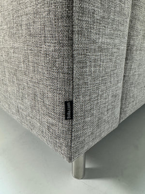 Gebrauchtes graues Bolia Scandinavia Designer Stoff Sofa mit Metallfüßen vor einer Wand, stilvoll und modern eingerichtet.