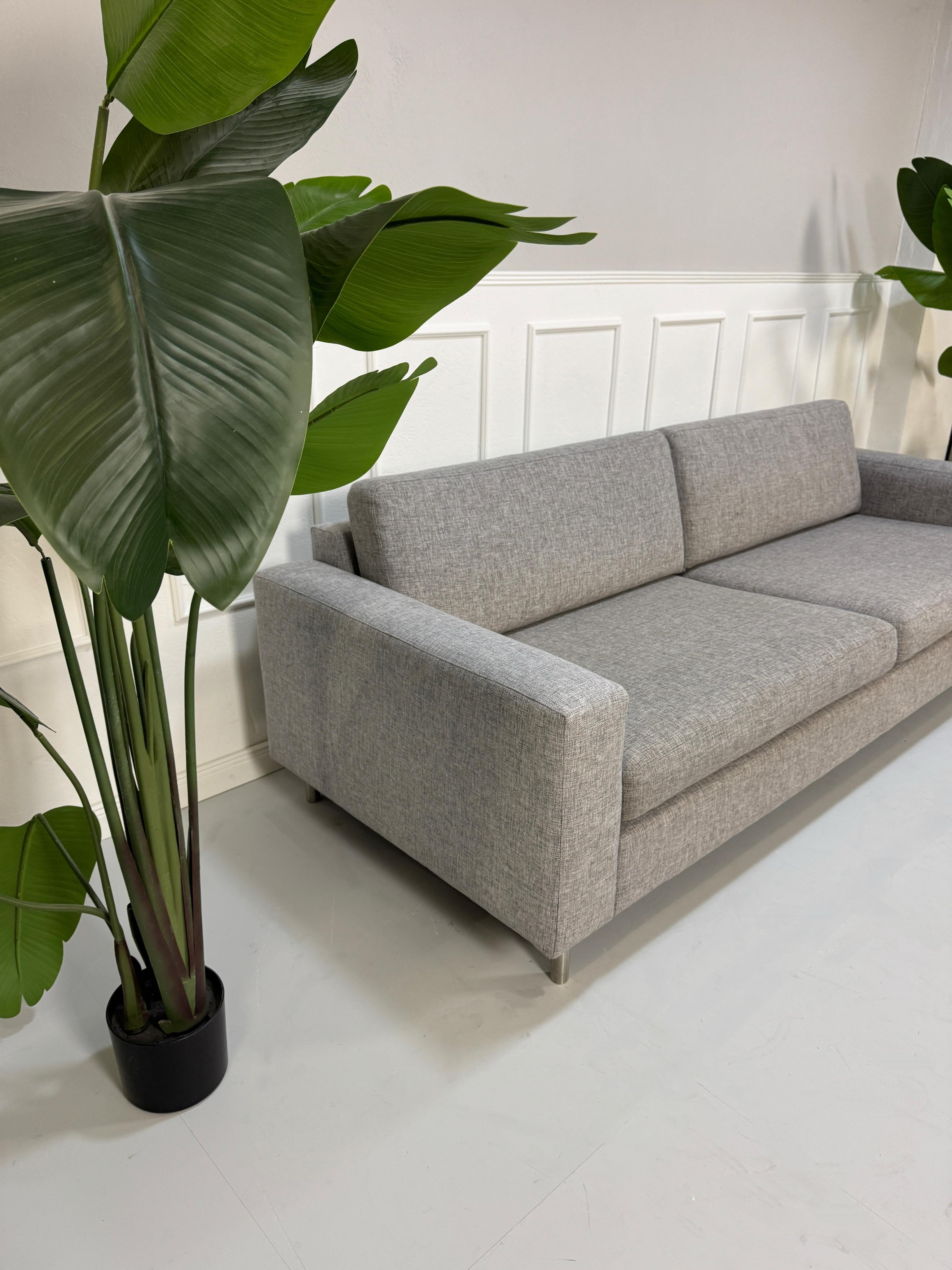 Gebrauchtes graues Bolia Scandinavia Designer Stoff Sofa mit Metallfüßen vor einer Wand, stilvoll und modern eingerichtet.