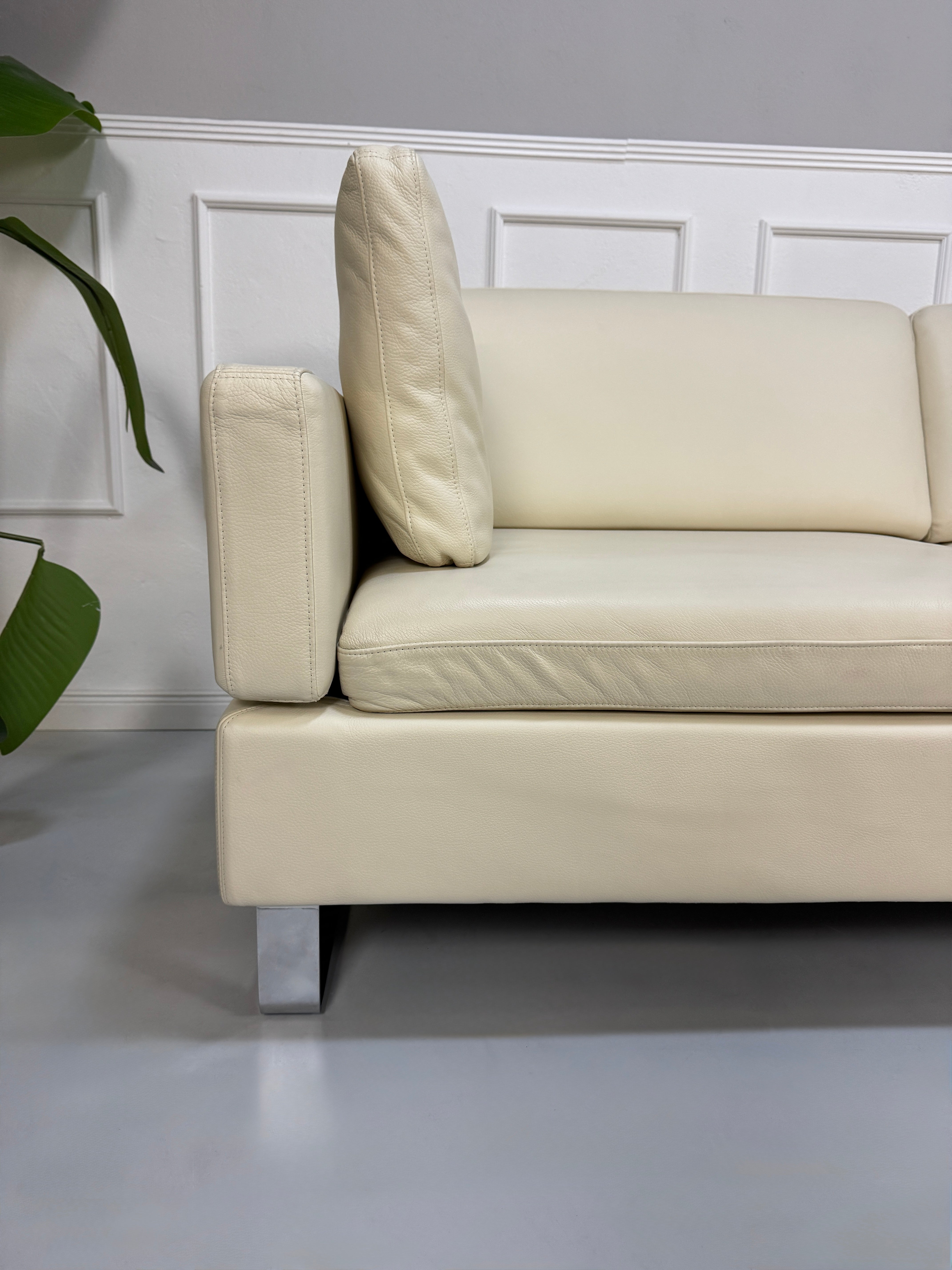 Gebrauchtes beiges Ledersofa Brühl Modell Alba vor einer modernen Wand