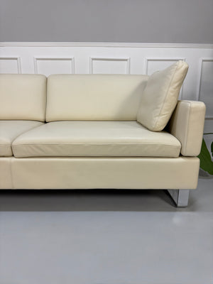 Gebrauchtes beiges Ledersofa Brühl Modell Alba vor einer modernen Wand