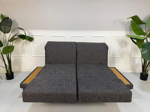 Ausstellungsstück Brühl Moule Designer Stoff Sofa in Grau vor einer Wand, stilvoll und modern eingerichtet.