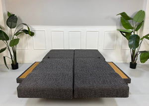 Ausstellungsstück Brühl Moule Designer Stoff Sofa in Grau vor einer Wand, stilvoll und modern eingerichtet.