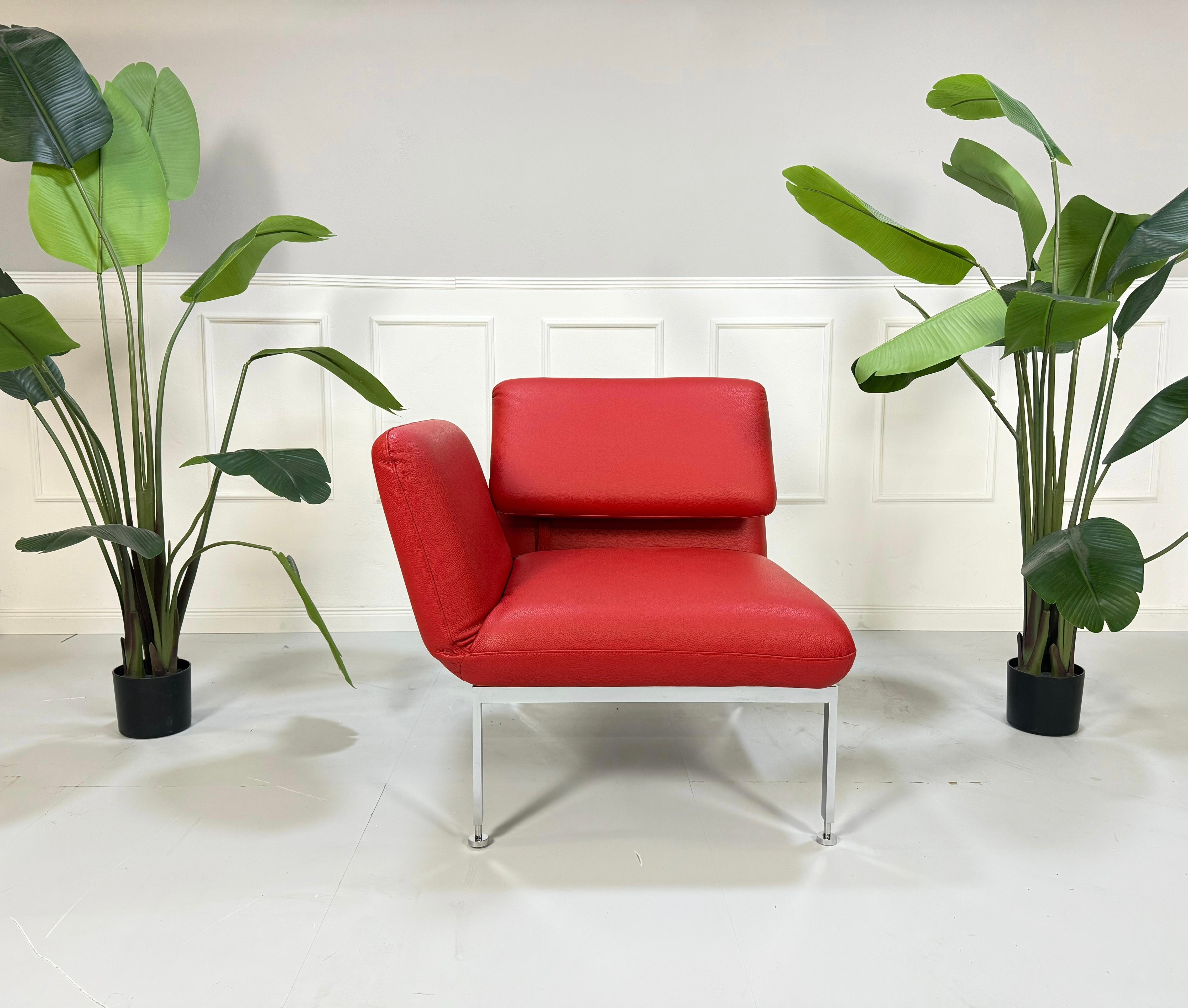 Gebrauchter roter Brühl Roro Leder Sessel vor einer Wand, stilvoll und modern eingerichtet.