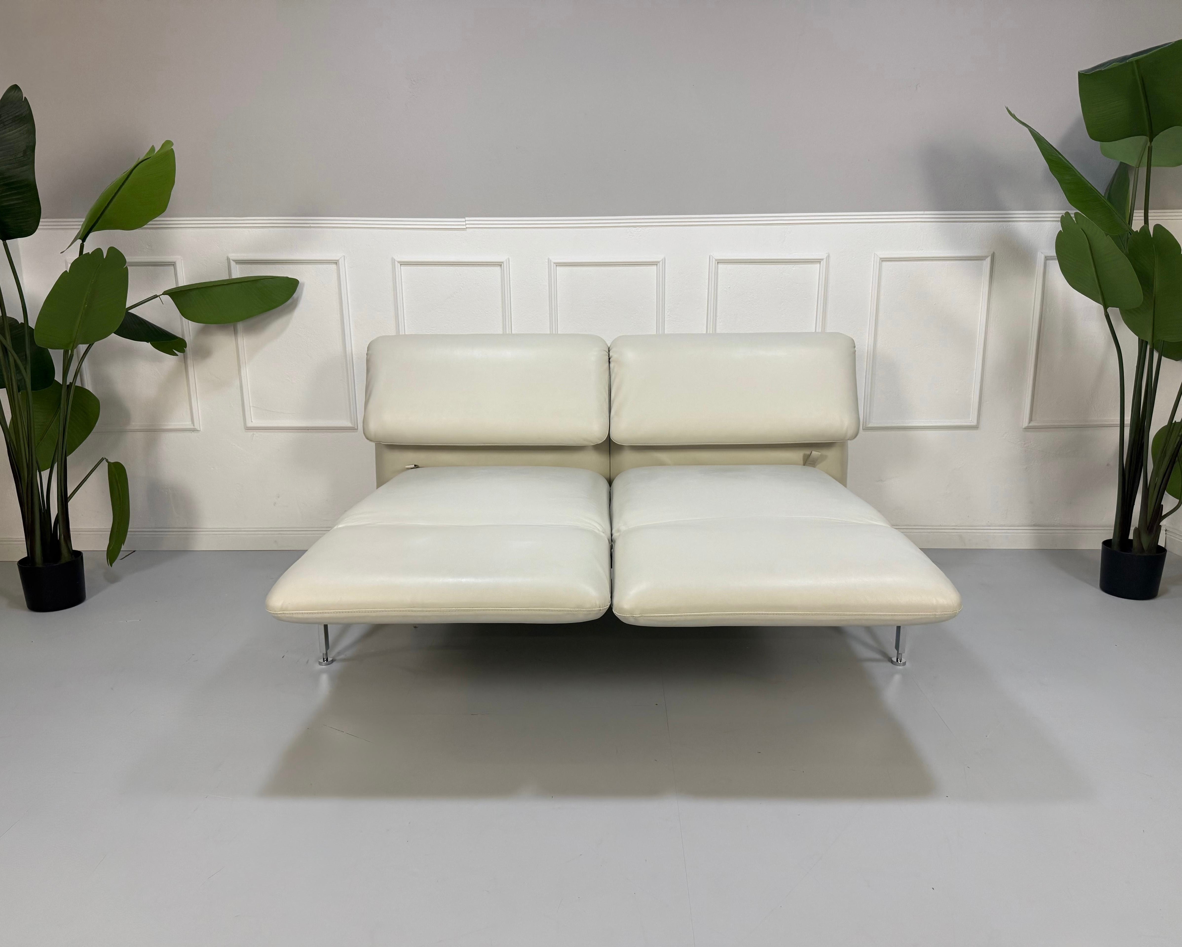 Gebrauchtes weißes Brühl Roro Designer Leder Sofa vor einer Wand, stilvoll und modern eingerichtet.