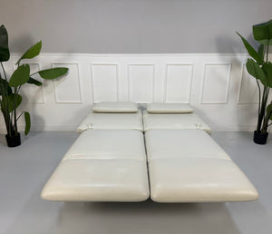 Gebrauchtes weißes Brühl Roro Designer Leder Sofa vor einer Wand, stilvoll und modern eingerichtet.