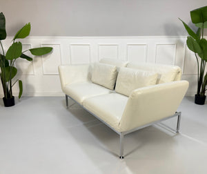 Gebrauchtes weißes Brühl Roro Designer Leder Sofa vor einer Wand, stilvoll und modern eingerichtet.