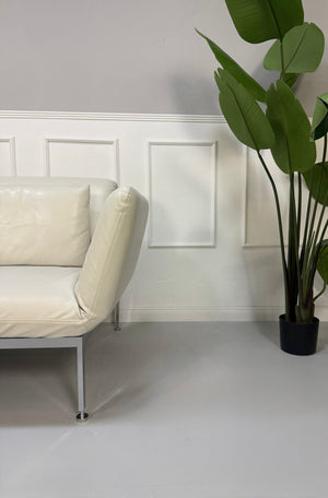 Gebrauchtes weißes Brühl Roro Designer Leder Sofa vor einer Wand, stilvoll und modern eingerichtet.