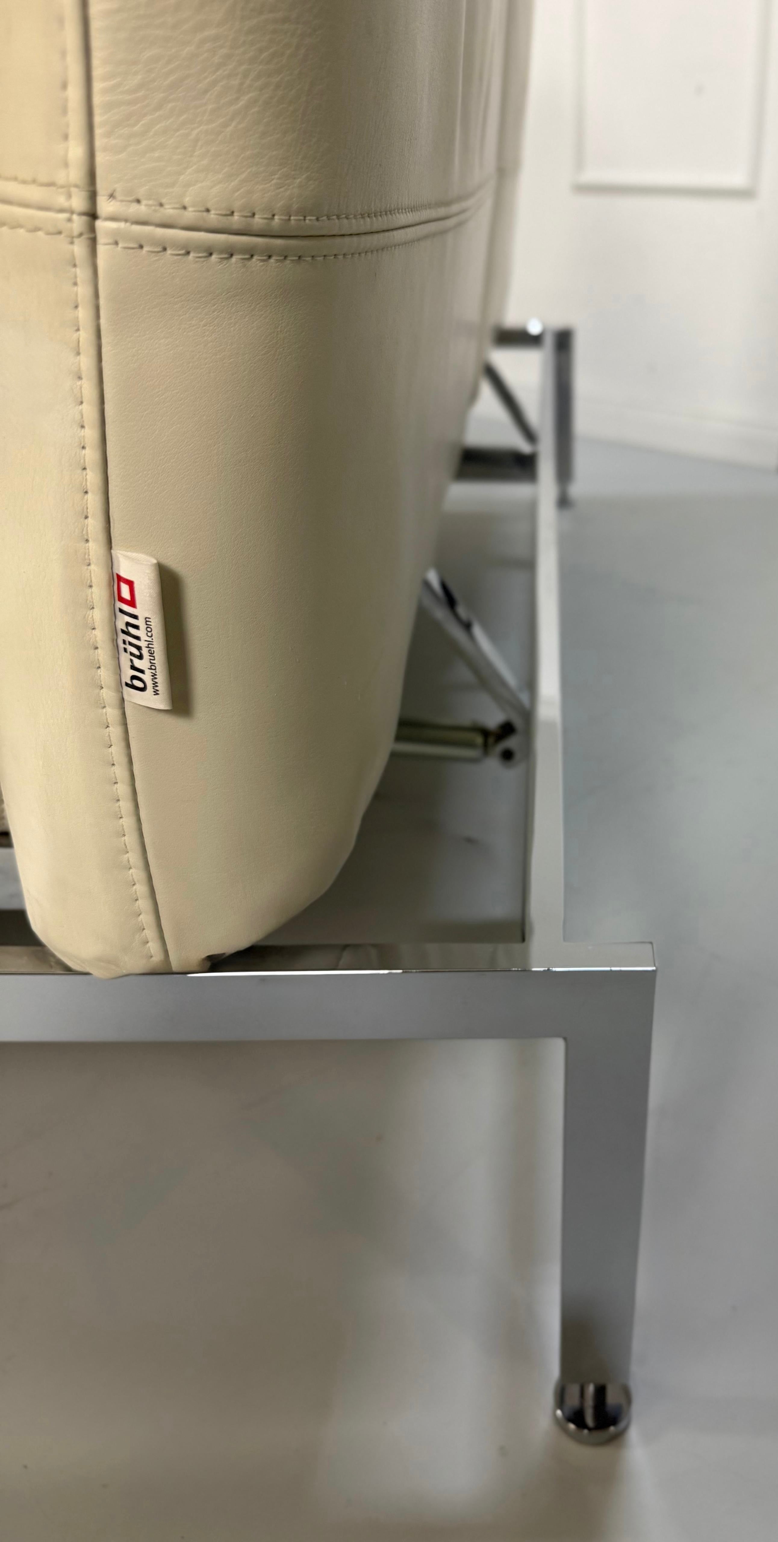 Gebrauchtes weißes Brühl Roro Designer Leder Sofa vor einer Wand, stilvoll und modern eingerichtet.