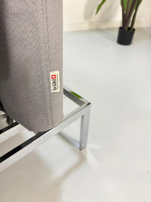 Erneuertes Brühl Roro Designer Stoff Sofa in der Farbe Grau vor einer Wand, stilvoll und modern eingerichtet.