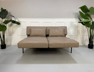 Erneuertes graues Brühl Roro Soft Designer Stoff Sofa vor einer Wand, stilvoll und modern eingerichtet.