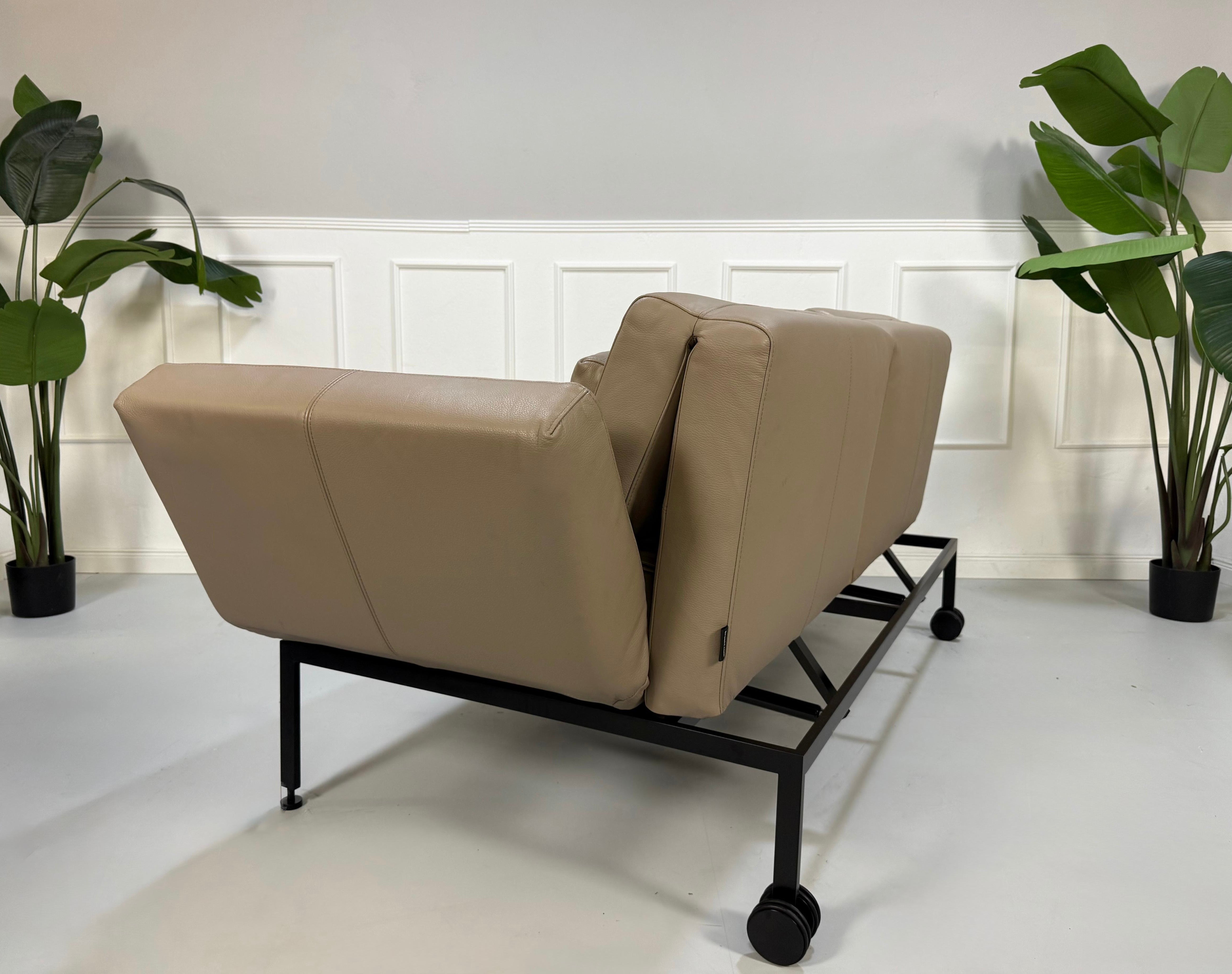 Erneuertes graues Brühl Roro Soft Designer Stoff Sofa vor einer Wand, stilvoll und modern eingerichtet.