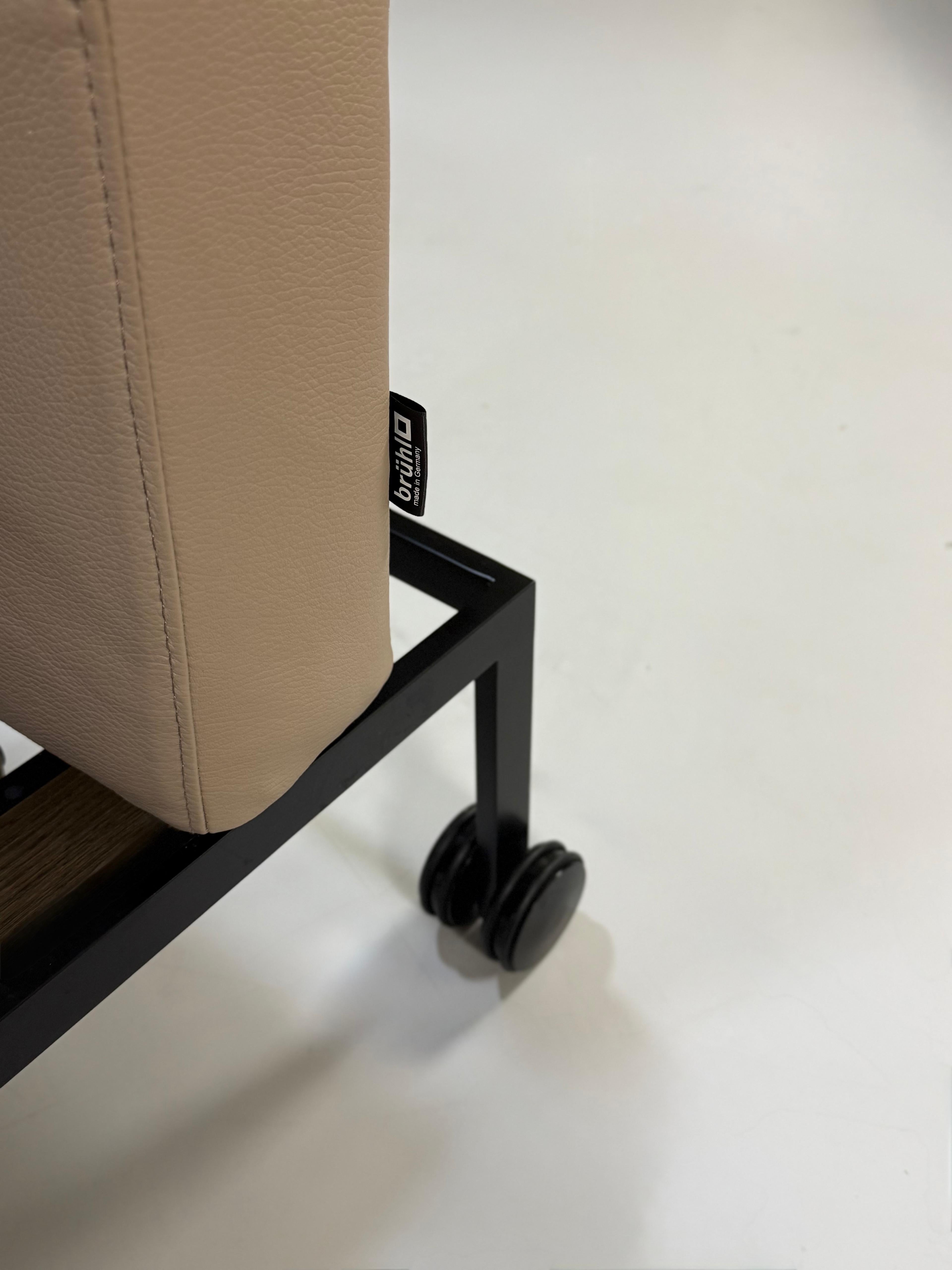 Erneuertes graues Brühl Roro Soft Designer Stoff Sofa vor einer Wand, stilvoll und modern eingerichtet.