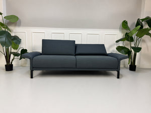 Gebrauchte graue Rolf Benz Cara Designer Stoff Sofa Garnitur vor einer Wand, stilvoll und modern eingerichtet.