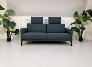 Gebrauchte graue Rolf Benz Cara Designer Stoff Sofa Garnitur vor einer Wand, stilvoll und modern eingerichtet.