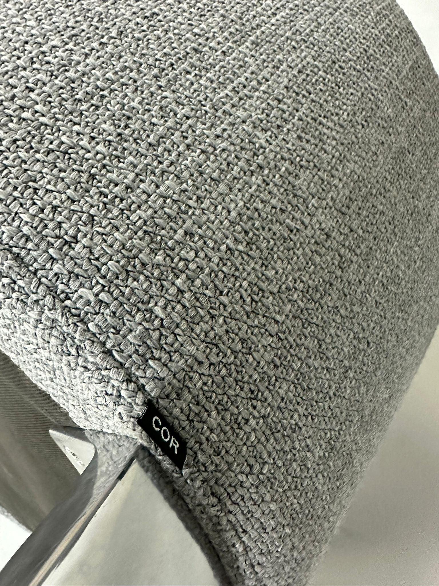 Gebrauchter COR Conic Tisch und Stühle in den Farben Weiß und Grau vor einer Wand, stilvoll und modern eingerichtet.