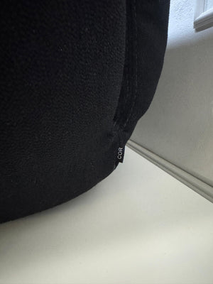 Refurbished COR Jalis in der Farbe Schwarz Designer Stoff Sofa vor einer Wand, stilvoll und modern eingerichtet.