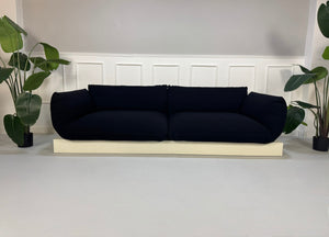Refurbished COR Jalis in der Farbe Schwarz Designer Stoff Sofa vor einer Wand, stilvoll und modern eingerichtet.