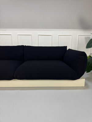Refurbished COR Jalis in der Farbe Schwarz Designer Stoff Sofa vor einer Wand, stilvoll und modern eingerichtet.