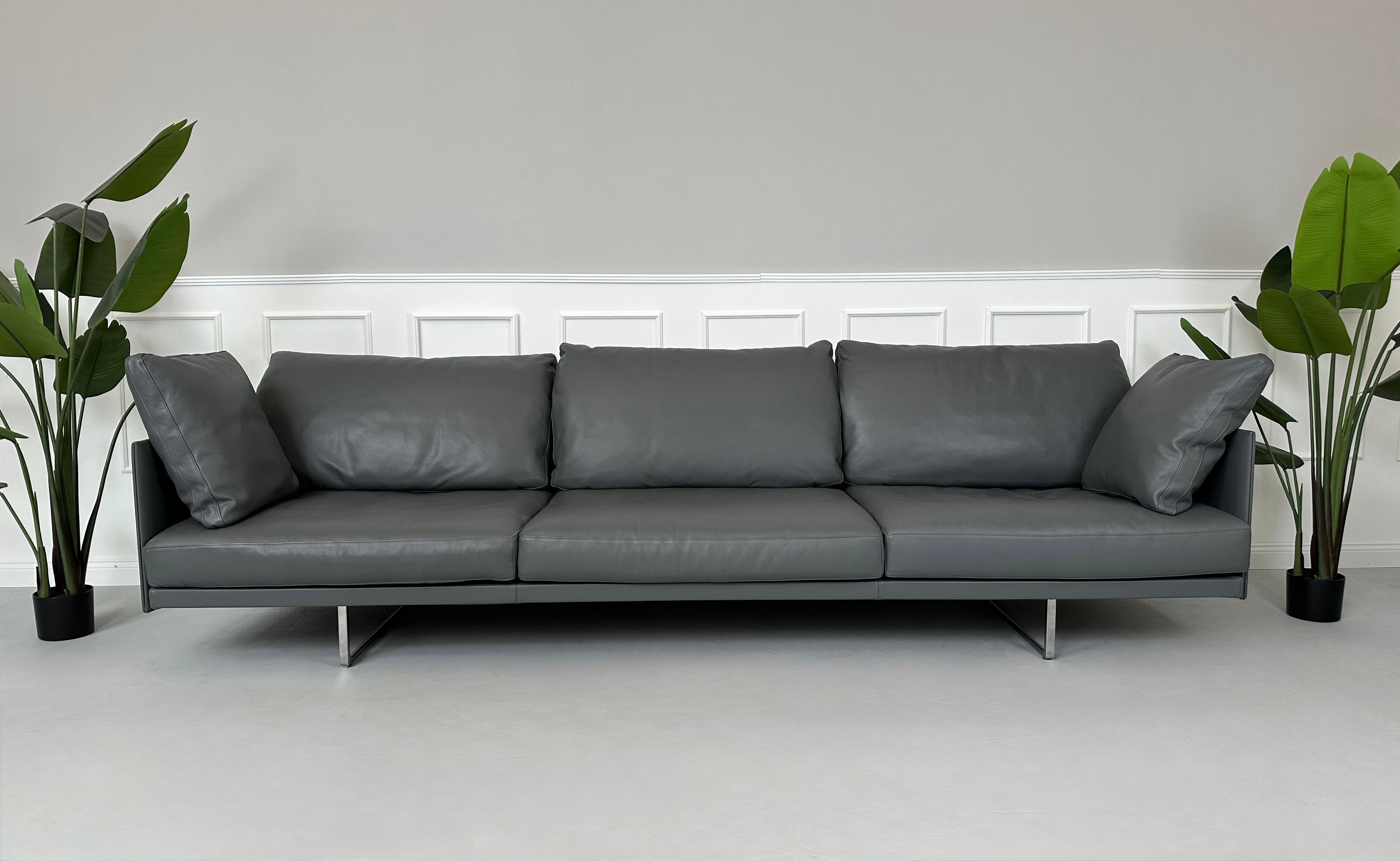 Gebrauchtes graues Cassina Toot Designer Leder Sofa vor einer Wand, stilvoll und modern eingerichtet.