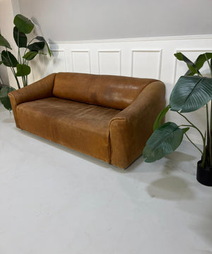 Gebrauchtes braunes DeSede DS47 Designer Leder Sofa vor einer Wand, stilvoll und modern eingerichtet.