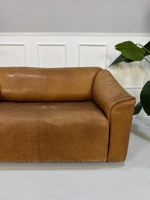 Gebrauchtes braunes DeSede DS47 Designer Leder Sofa vor einer Wand, stilvoll und modern eingerichtet.