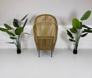 Gebrauchter outdoor DEDON Rilly Cocoon Garten Stuhl vor einer Wand, stilvoll und modern eingerichtet.