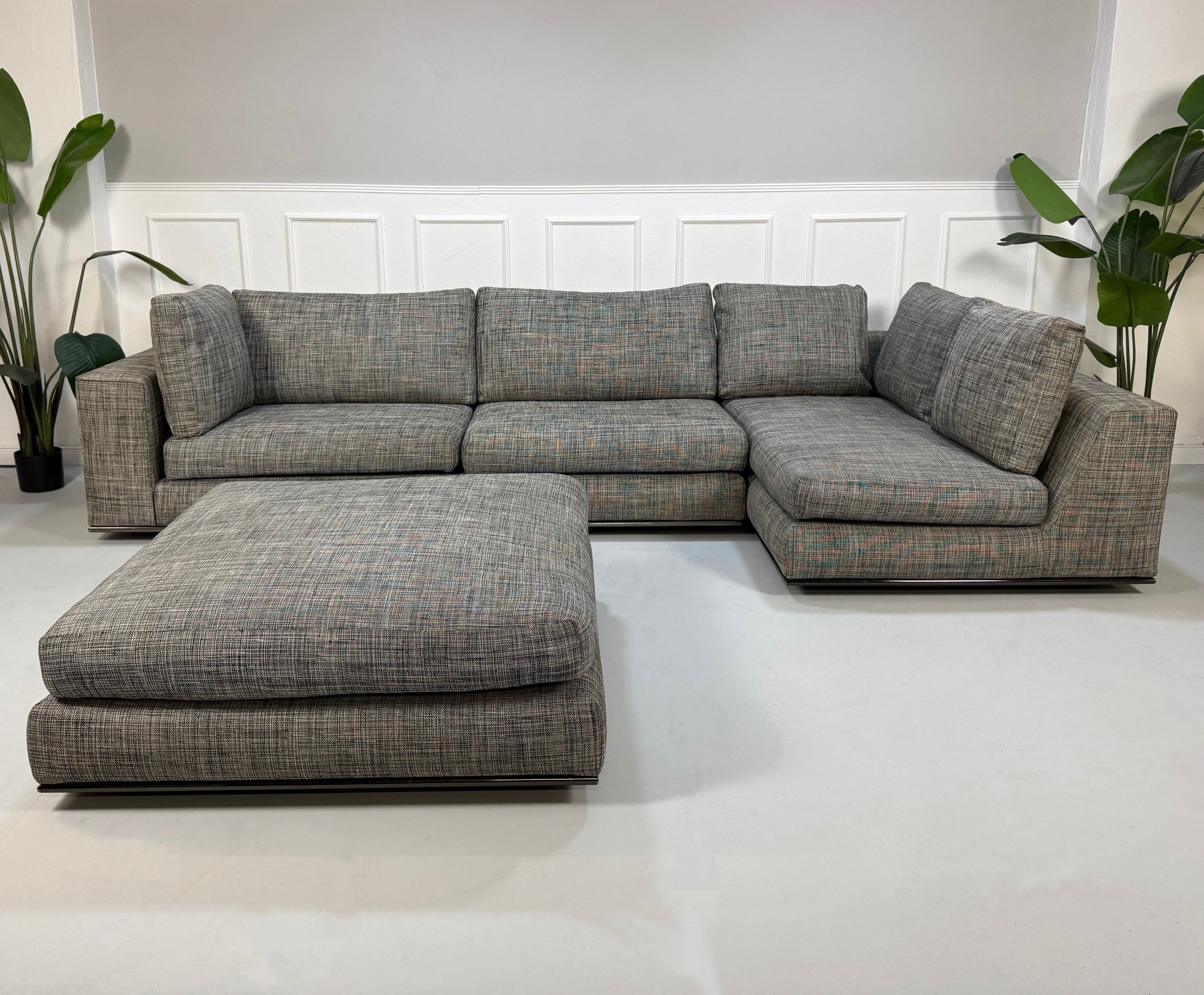 Gebrauchtes graues Minotti Hamilton Designer Stoff Sofa vor einer Wand, stilvoll und modern eingerichtet.